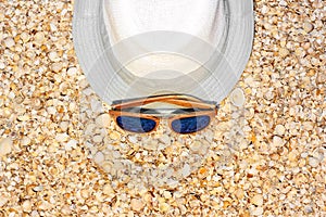 Summer hat and sunglasses on shells. Seashells background. Summer. Relaxation