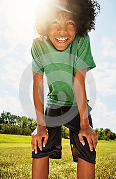 Summer, here I come. Portrait of a happy boy standing outside on a bright summers day.