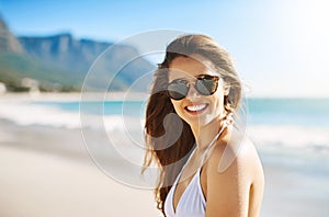Summer is here and I couldnt be happier. Closeup shot of a beautiful young woman spending some time at the beach.