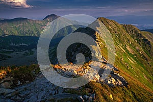 Summer hiking in the mountains with massive rocks, dramatic skies and majestic mountains.