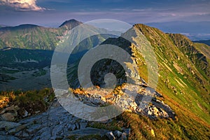 Summer hiking in the mountains with massive rocks, dramatic skies and majestic mountains.