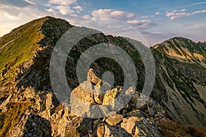 Summer hiking in the mountains with massive rocks, dramatic skies and majestic mountains.