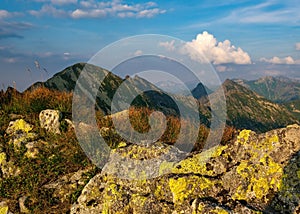 Summer hiking in the mountains with massive rocks, dramatic skies and majestic mountains.