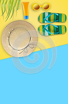 Summer holiday background, Beach accessories, Vacation and travel items. Flipflop, Sun glassed, Straw hat and Sunblock on yellow