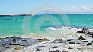 Summer holiday at the beach. South of Spain. Mediterranean coast. Turquoise sea. Sea mark and lighthouse pier