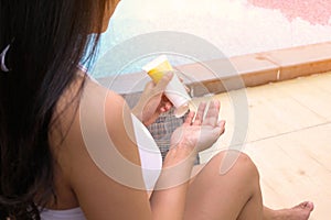 Summer holiday with Body Sun protection suncream Young asian Beautiful woman applying sunscreen creme on tanned Skincare