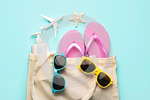 Summer holiday concept.Top view of beach bag with flip flops,sunglasses,sunscreen,airplane and starfish