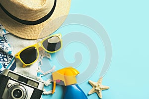 Summer holiday concept.Top view of beach towel,sunglasses,hat,sunscreen and vintage photo camera with space for text