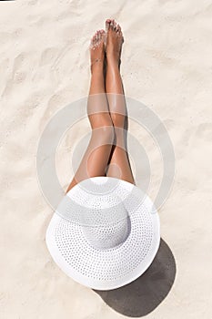 Summer holiday fashion concept - tanning woman wearing sun hat a