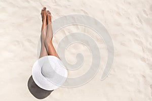 Summer holiday fashion concept - tanning woman wearing sun hat a