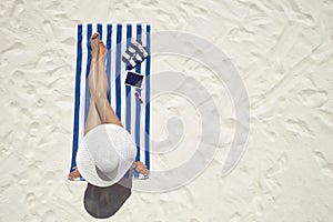 Summer holiday fashion concept - tanning woman wearing sun hat a