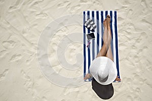 Summer holiday fashion concept - tanning woman wearing sun hat a