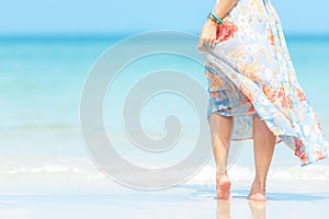 Summer Holiday.  Lifestyle smiling asian woman wearing dress fashion summer trips relax on the sandy ocean beach.