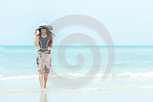 Summer Holiday. Lifestyle woman chill holding big white hat and wearing bikini fashion summer trips walking on the sandy ocean bea