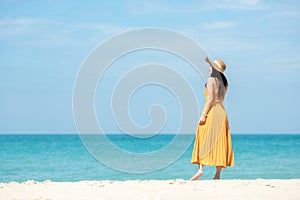 Summer Holiday. Lifestyle woman chill with yellow wearing dress fashion summer trips standing chill on the sandy ocean beach.