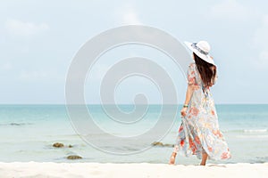 Summer Holiday.   Lifestyle woman wearing fashion summer trips standing on the sandy ocean beach. Happy woman enjoy and relax vaca