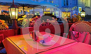 summer holiday  light city  night Street cafe  bokeh blurring city light evening restaurant table cup of coffee on top view candl