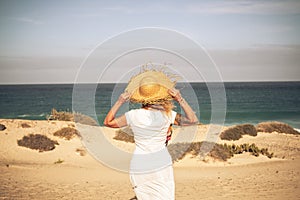 Summer holiday tourist vacation concept with people woman with white dress and hat viewed from back looking wonderful natural