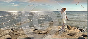 Seascape women relax in  summer hat and yellow dress sunset pink sky relaxing stay on rock stone at pier beach sea water seagull