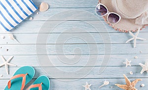 Summer holiday, travel and vacation concept. Sunglasses, starfish, beach hat, flip flop and sea shell on pastel blue wooden