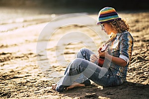 Summer holiday vacation for artist hippy lifestyle independent people beautiful blonde woman sitting on the sand with coloured