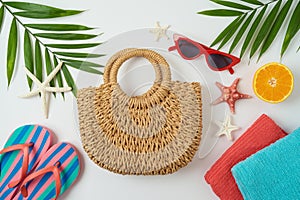 Summer holiday vacation concept with fashion bag, palm tree leaves and beach accessories on white background. Top view from above