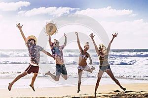 Summer holiday vacation travel concept with young group of people friends jumping for happiness and joy at the beach with blue sea