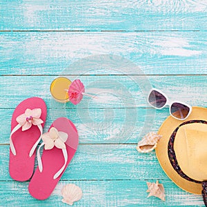 Summer Holidays in Beach Seashore. Fashion accessories summer flip flops, hat, sunglasses on bright turquoise board near the pool