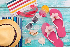 Summer Holidays in Beach Seashore. Fashion accessories summer flip flops, hat, sunglasses on bright turquoise board near the pool