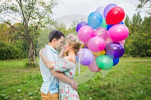 Summer holidays, celebration and dating concept - couple with colorful balloons in nature