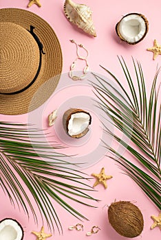 Summer holidays concept. Top vertical view photo of sunhat cracked coconuts shell bracelet earrings starfishes and palm leaves on