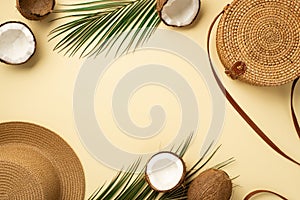 Summer holidays concept. Top view photo of hat round rattan bag cracked coconuts and green palm leaves on isolated beige