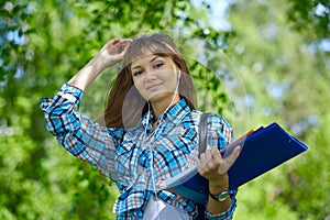 Summer holidays, education, campus and teenage concept - smiling female student with folders