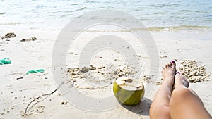 Coconut and legs on the white beach photo