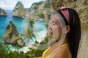 Summer holidays portrait of young beautiful and happy Asian Chinese woman in bikini enjoying amazing sea scene at tropical