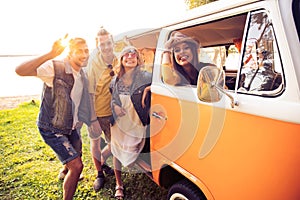 Summer holidays, road trip, vacation, travel and people concept - smiling young hippie friends having fun over minivan