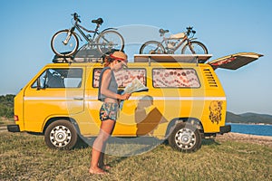Young hippie women in front of minivan car on beach photo