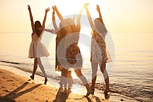 Summer holidays and vacation - girls with hands up on the beach. bare feet girls in the water at an sea resort. summer vibes. hen-