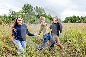 Summer holidays vacation happy people concept. Group of three friends boy and two girls dancing and having fun together outdoors.