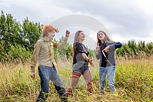 Summer holidays vacation happy people concept. Group of three friends boy and two girls dancing and having fun together outdoors.