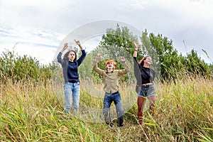 Summer holidays vacation happy people concept. Group of three friends boy and two girls dancing and having fun together outdoors.