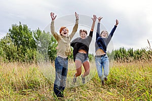 Summer holidays vacation happy people concept. Group of three friends boy and two girls jumping, dancing and having fun together