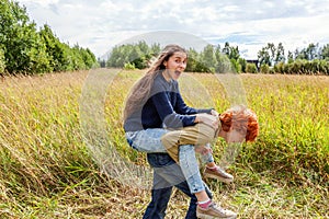 Summer holidays vacation happy people concept. Loving couple having fun in nature outdoors. Happy young man piggybacking his