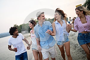 Group of friends having fun on the beach. Summer holidays, vacation and people concept.