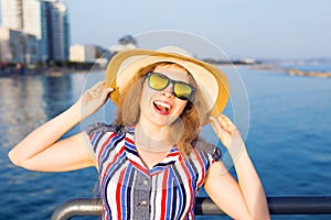 Summer holidays, vacation, travel and people concept - smiling laughing young woman wearing sunglasses and hat on beach