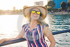 Summer holidays, vacation, travel and people concept - smiling young woman wearing sunglasses and hat on beach over sea