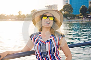 Summer holidays, vacation, travel and people concept - smiling young woman wearing sunglasses and hat on beach over sea