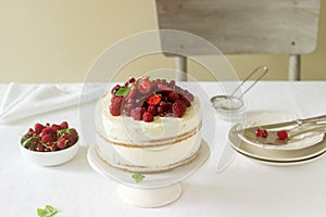 Summer home biscuit cake with curd cream, decorated with fresh berries of strawberries, raspberries and currants.