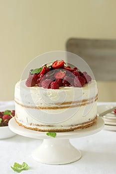 Summer home biscuit cake with curd cream, decorated with fresh berries of strawberries, raspberries and currants.