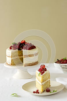 Summer home biscuit cake with curd cream, decorated with fresh berries of strawberries, raspberries and currants.